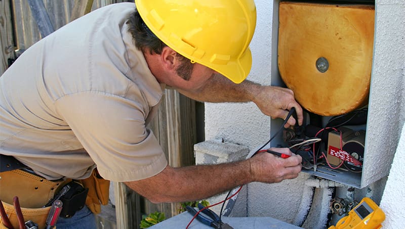 Commercial HVAC technician working on an electrical box
